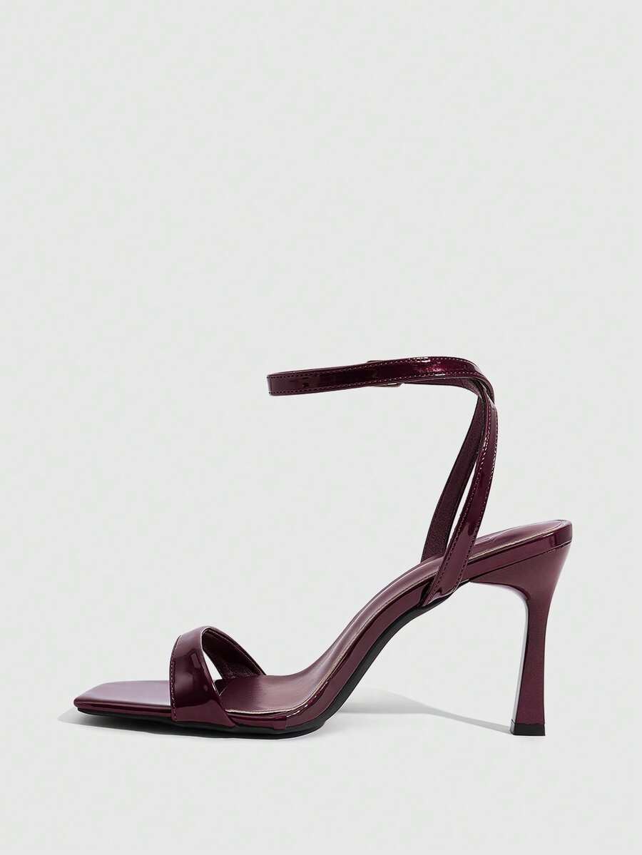 Women's high heel ankle strap sandals with open toe and stiletto heel in mirror black finish.