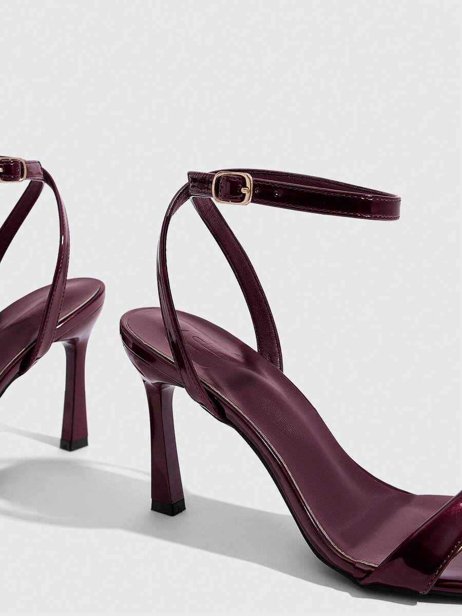 Women's high heel ankle strap sandals with open toe and stiletto heel in mirror black finish.