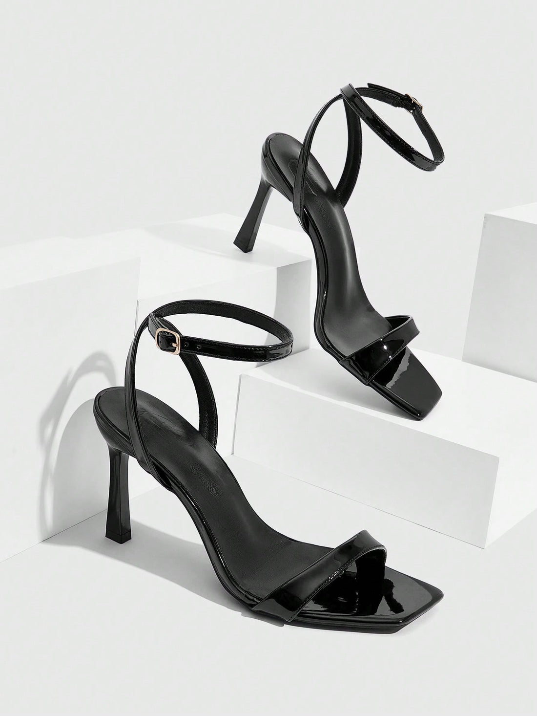 Women's high heel ankle strap sandals with open toe and stiletto heel in mirror black finish.