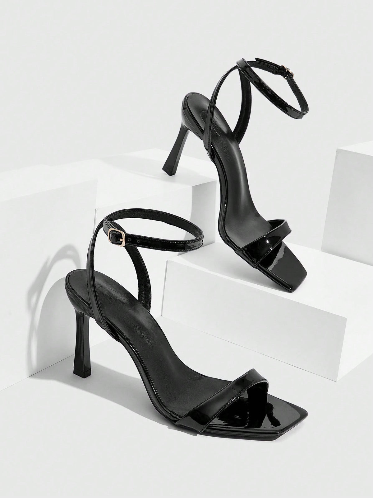 Women's high heel ankle strap sandals with open toe and stiletto heel in mirror black finish.