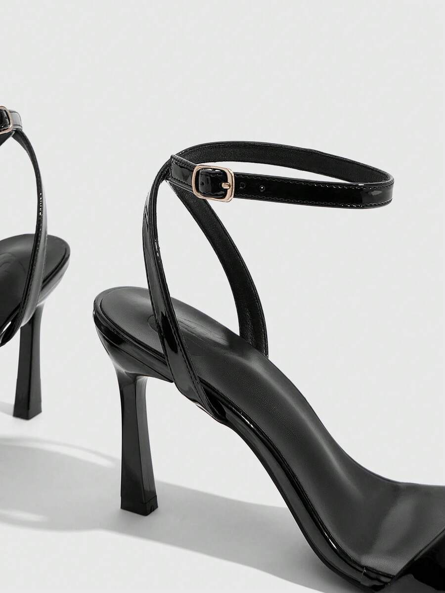 Women's high heel ankle strap sandals with open toe and stiletto heel in mirror black finish.