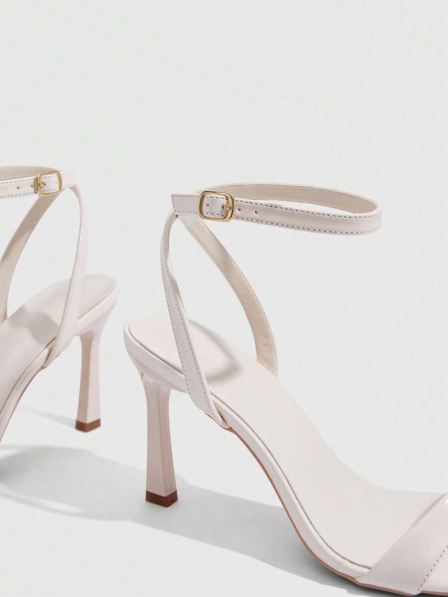 Women's high heel ankle strap sandals with open toe and stiletto heel in mirror black finish.