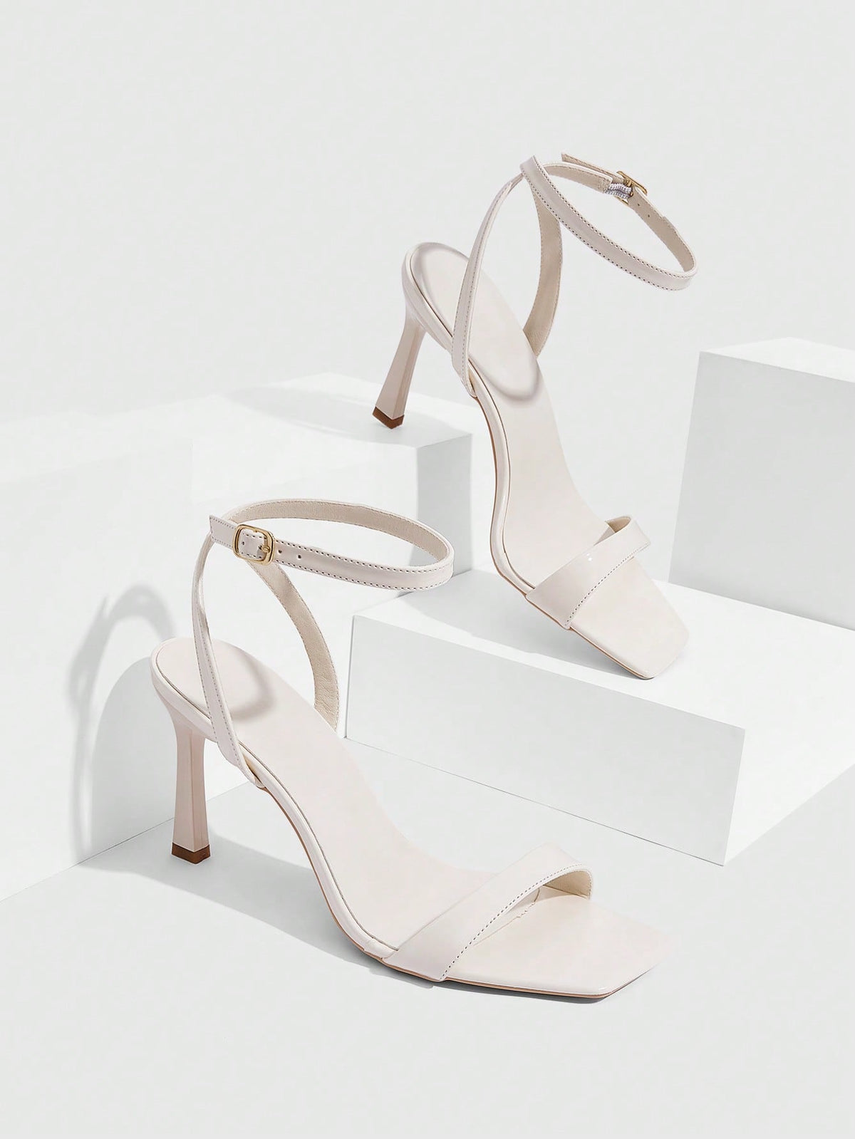 Women's high heel ankle strap sandals with open toe and stiletto heel in mirror black finish.