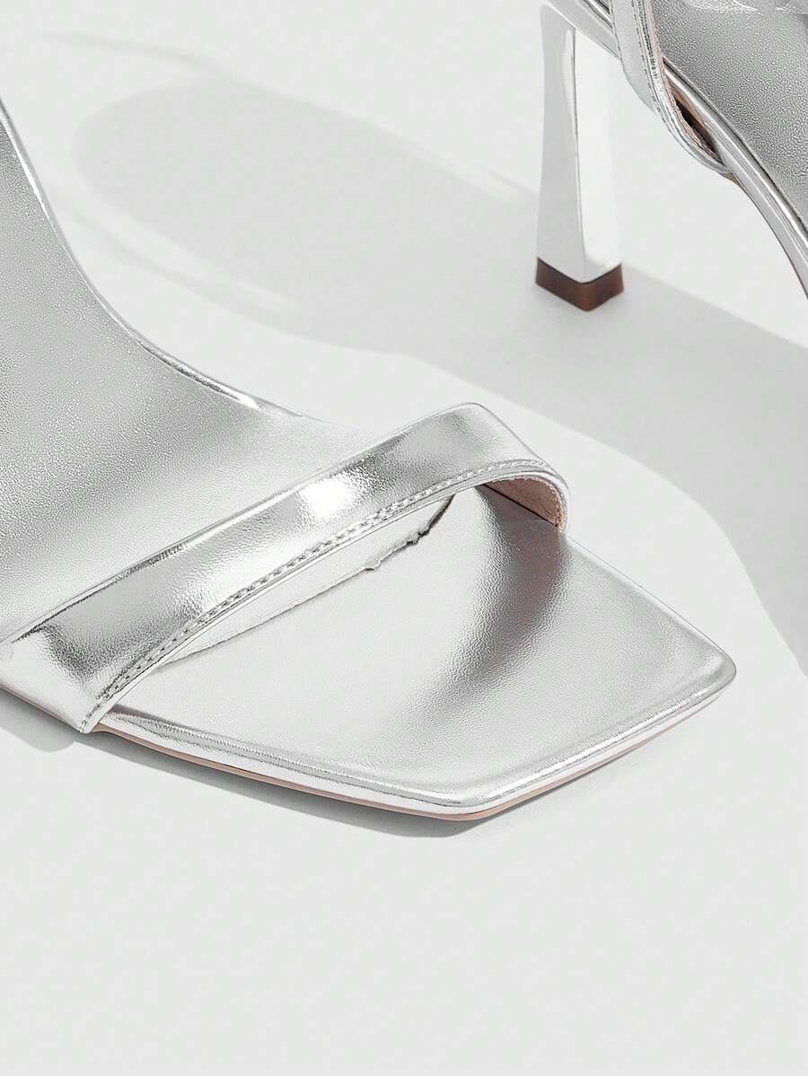 Women's high heel ankle strap sandals with open toe and stiletto heel in mirror black finish.