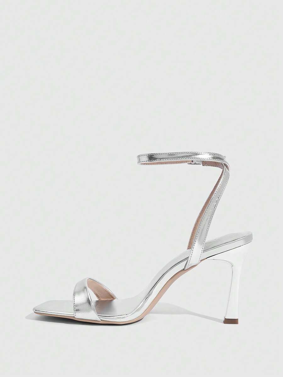 Women's high heel ankle strap sandals with open toe and stiletto heel in mirror black finish.