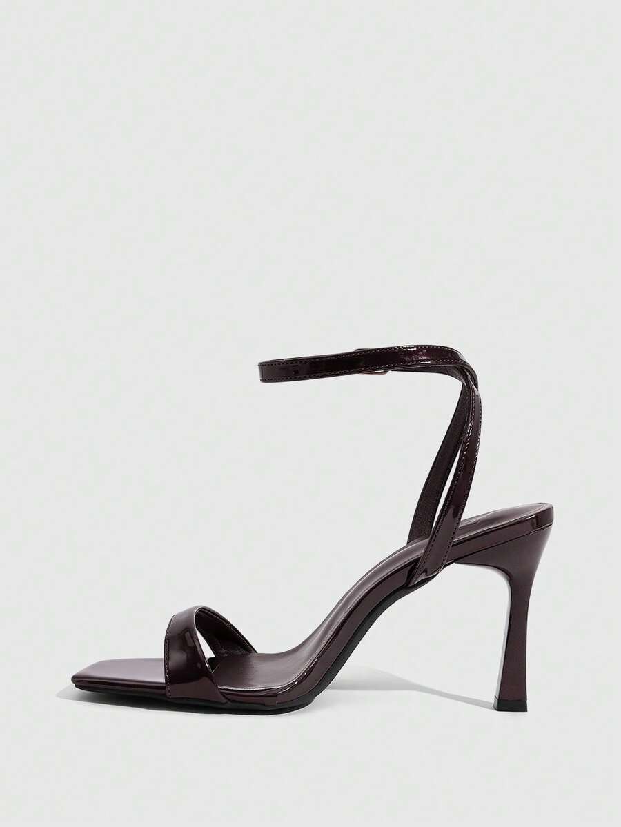 Women's high heel ankle strap sandals with open toe and stiletto heel in mirror black finish.