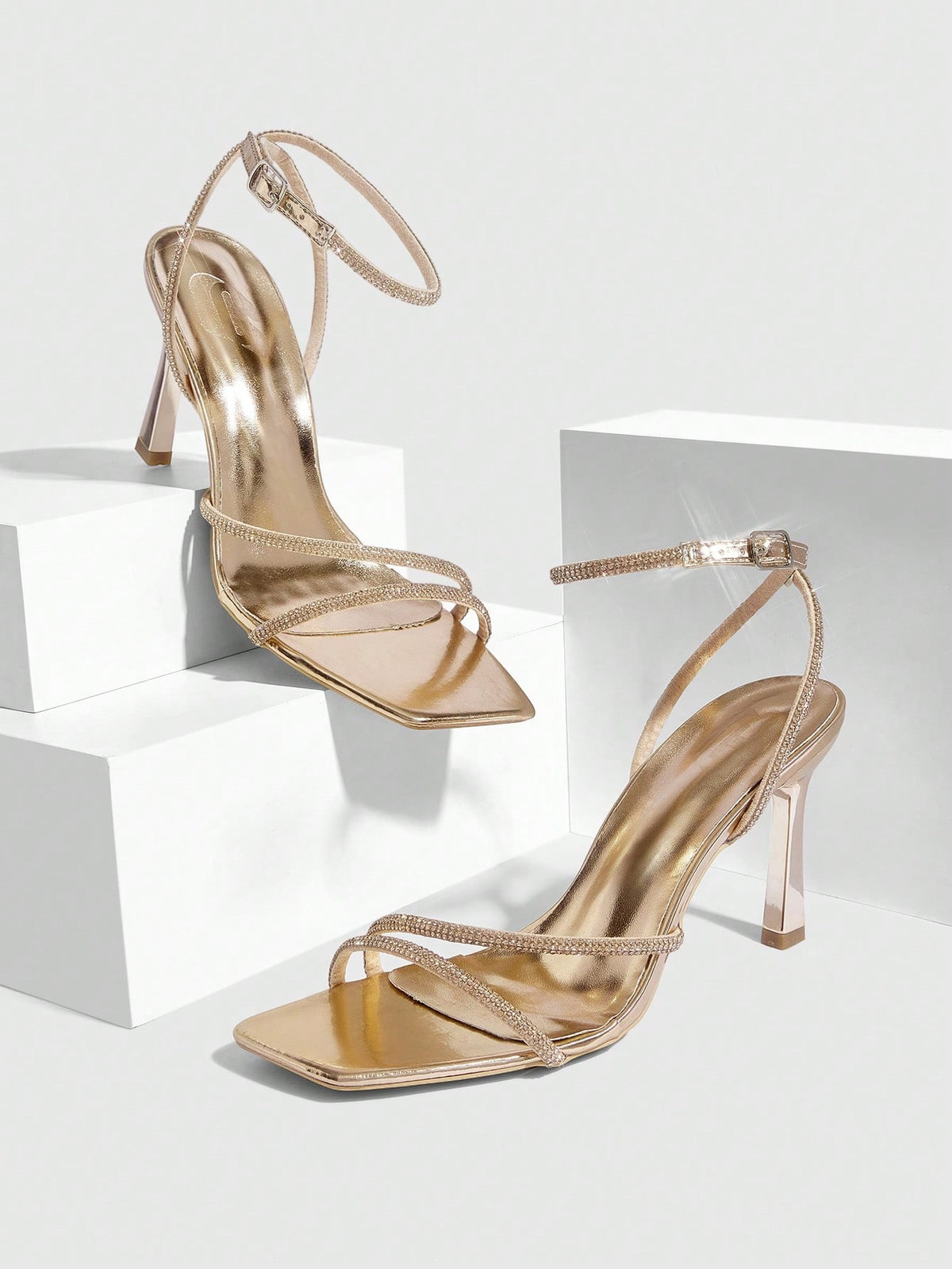 Champagne rhinestone ankle strap heeled sandals with open toe and high stiletto heel for women.
