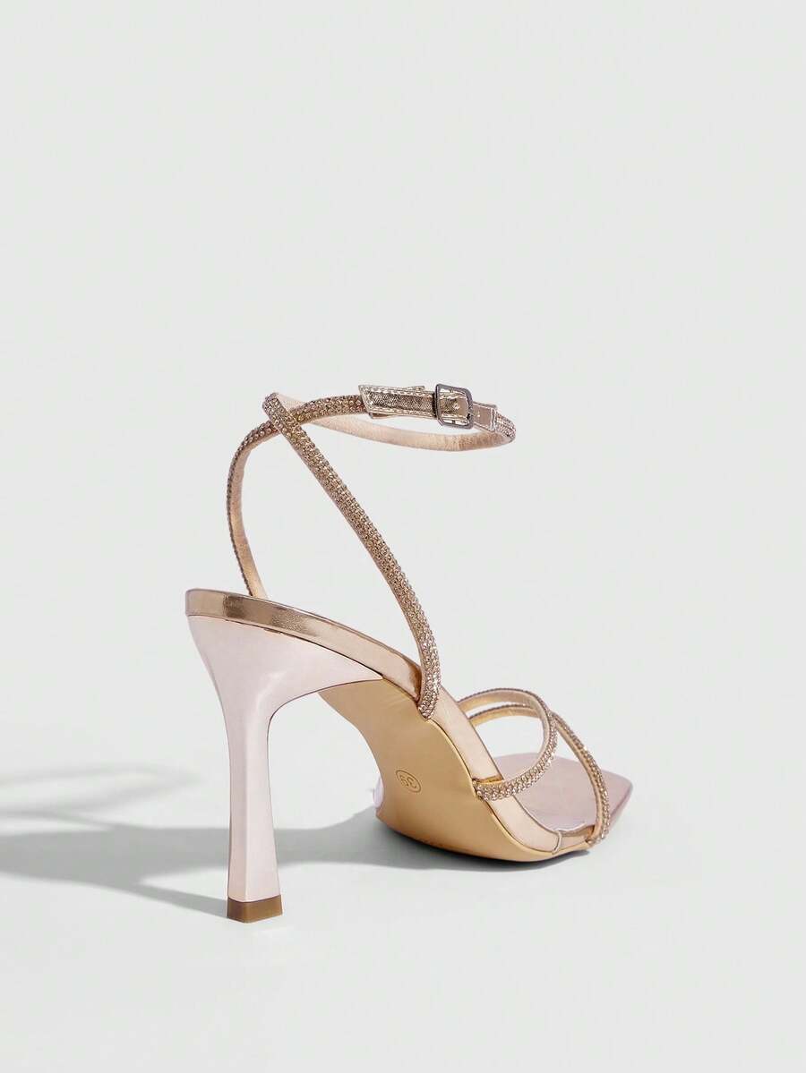 Champagne rhinestone ankle strap heeled sandals with open toe and high stiletto heel for women.