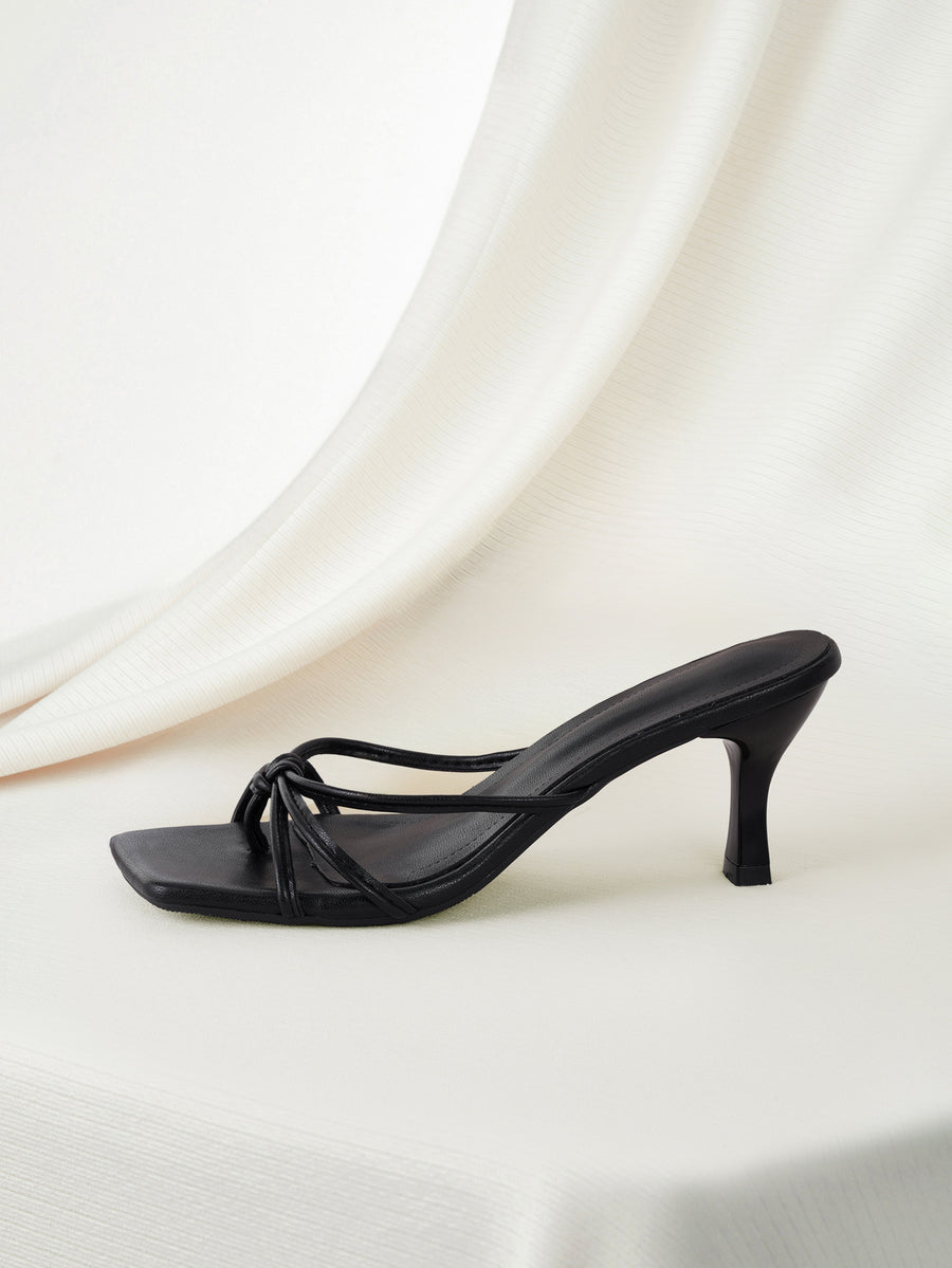 Black square toe stiletto heel sandals featuring criss-cross slip-on straps and a kitten heel mule design.