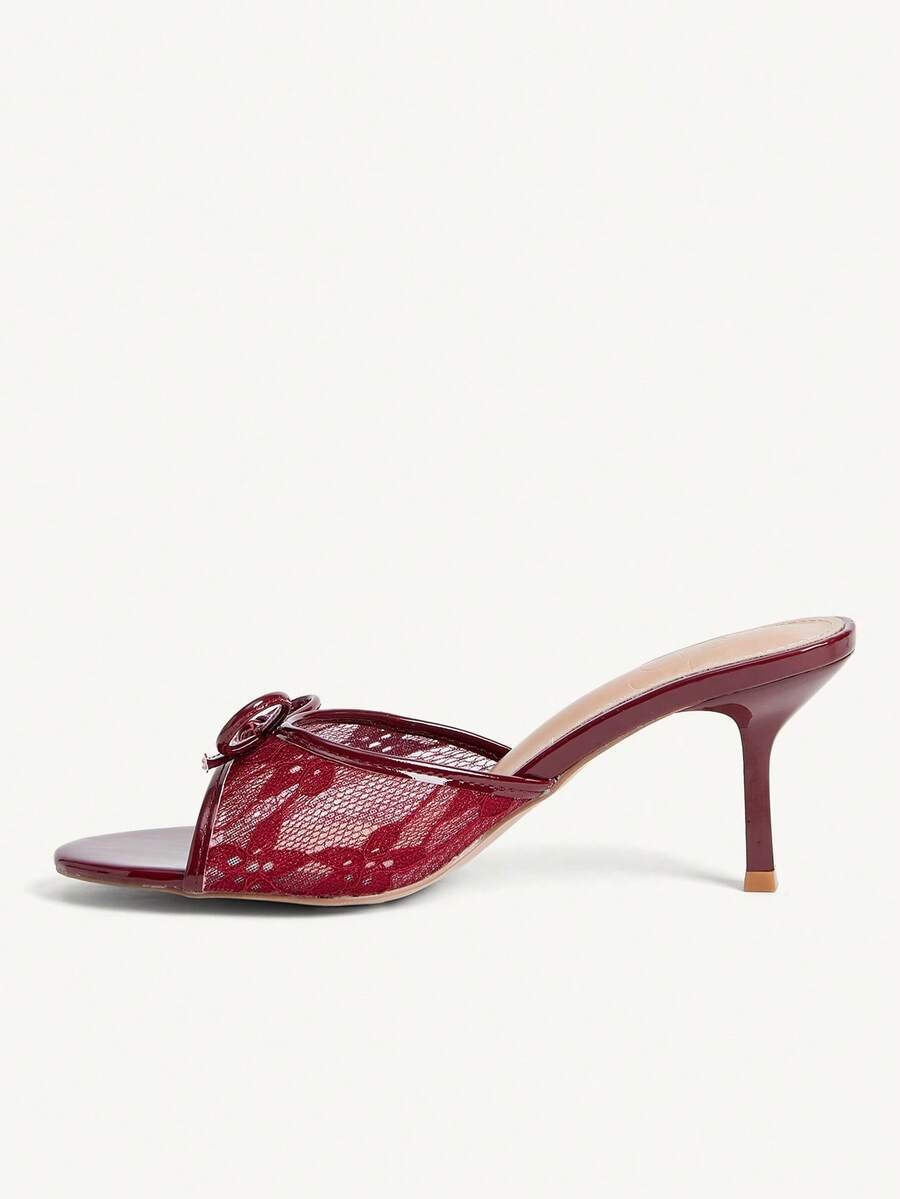 Open toe high heel slide sandals featuring lace details and a bow accent on the upper strap.