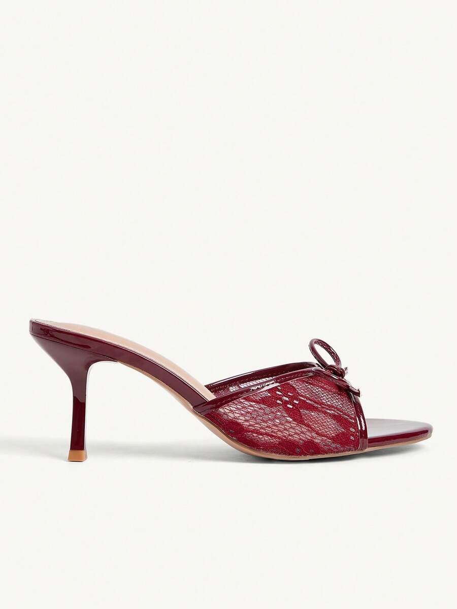 Open toe high heel slide sandals featuring lace details and a bow accent on the upper strap.