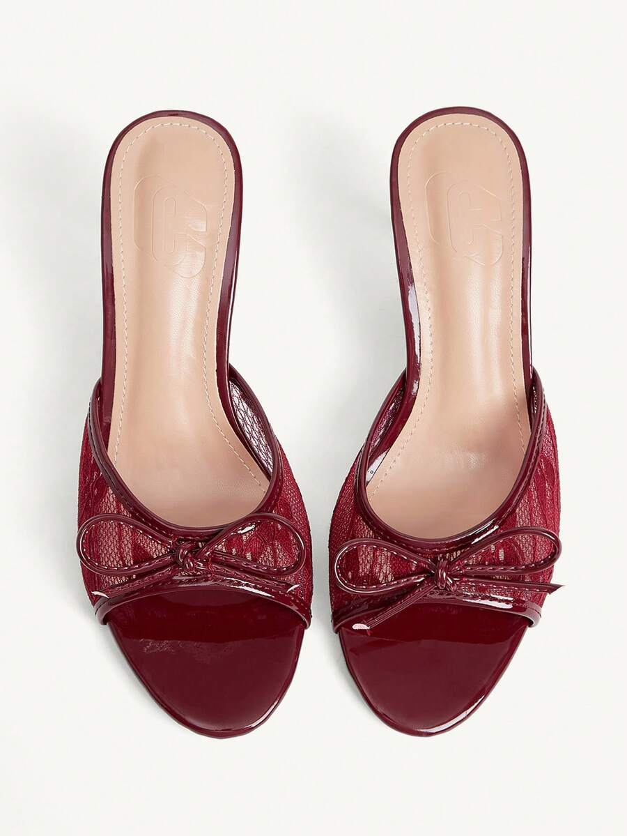 Open toe high heel slide sandals featuring lace details and a bow accent on the upper strap.