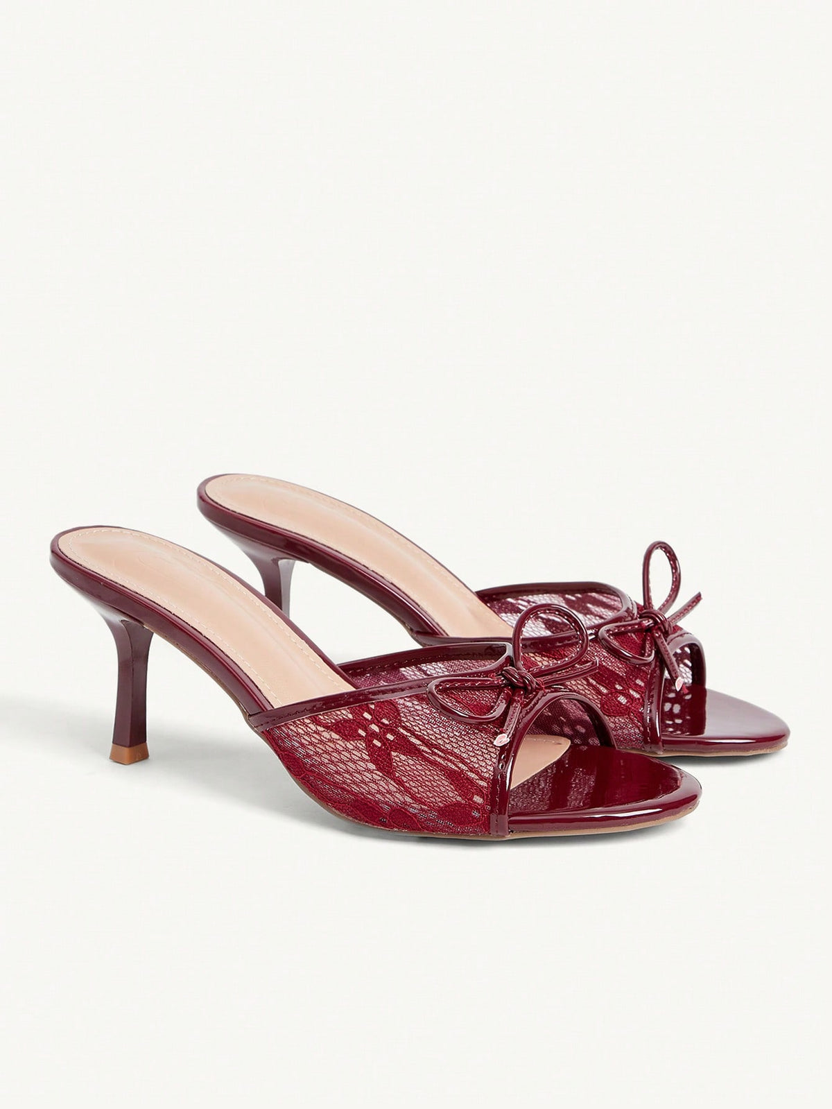 Open toe high heel slide sandals featuring lace details and a bow accent on the upper strap.