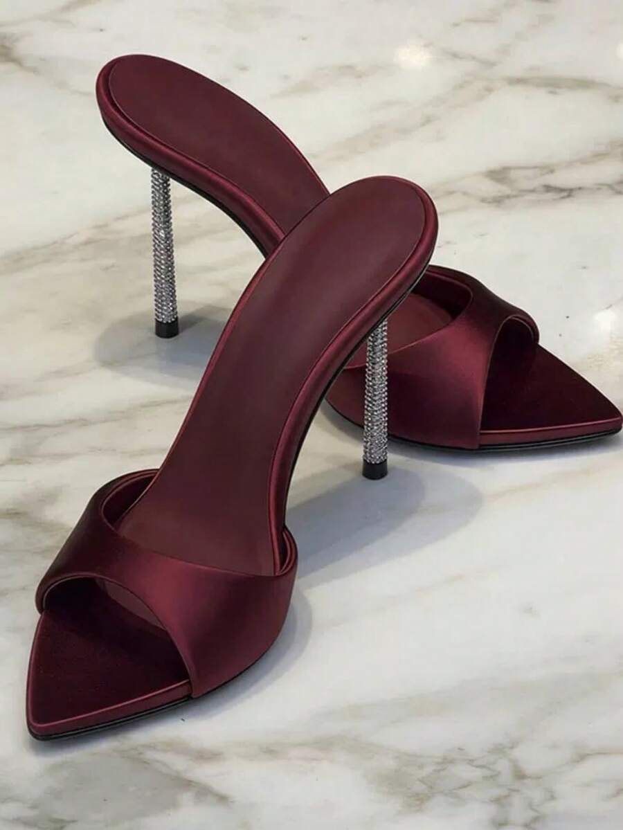 Women's black satin stiletto heeled sandals with sparkling rhinestone embellishments and a pointed peep toe design.