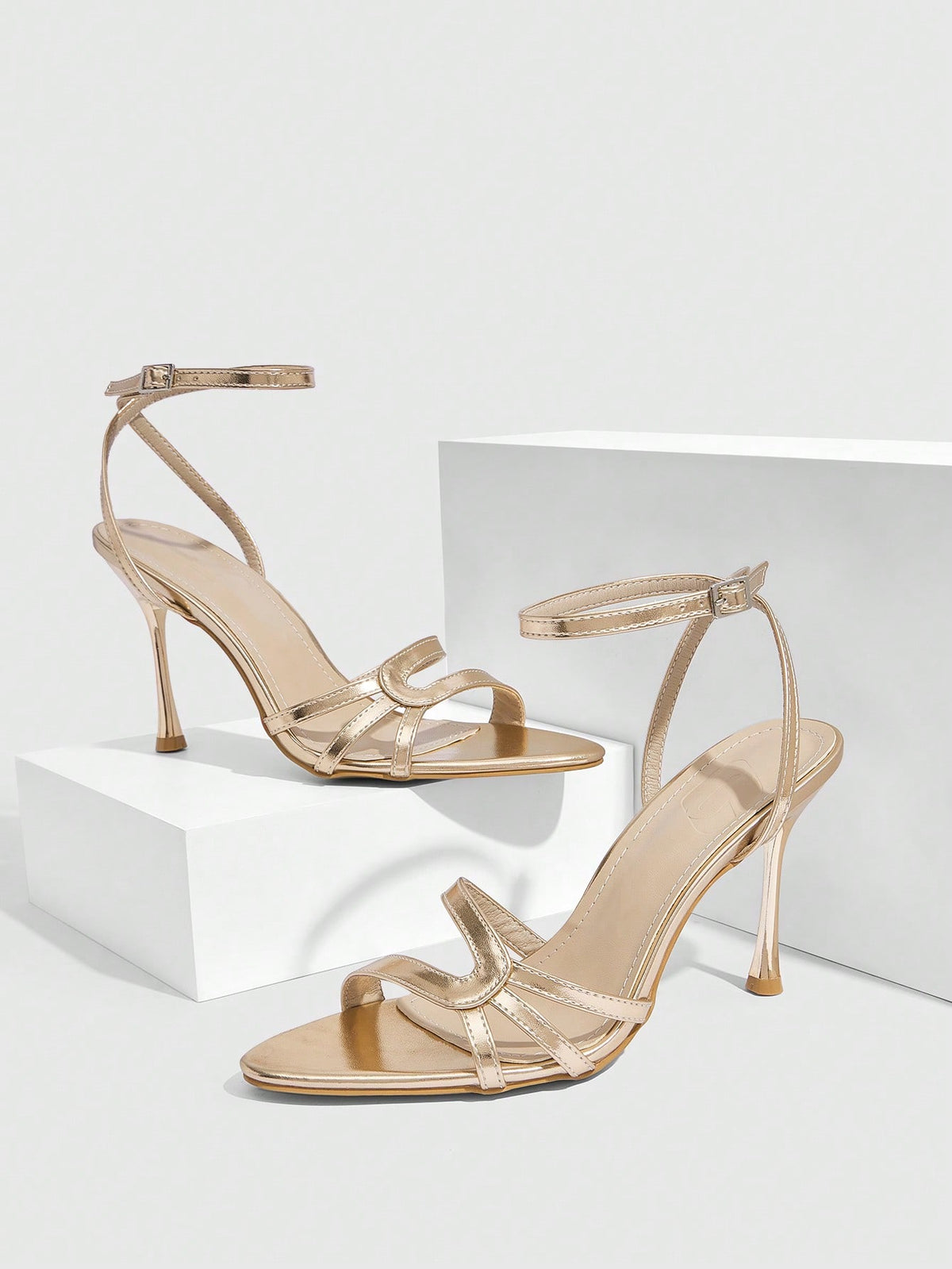 Women's open round toe high heel sandals with thin stiletto heel, hollow strap design, and ankle buckle closure.