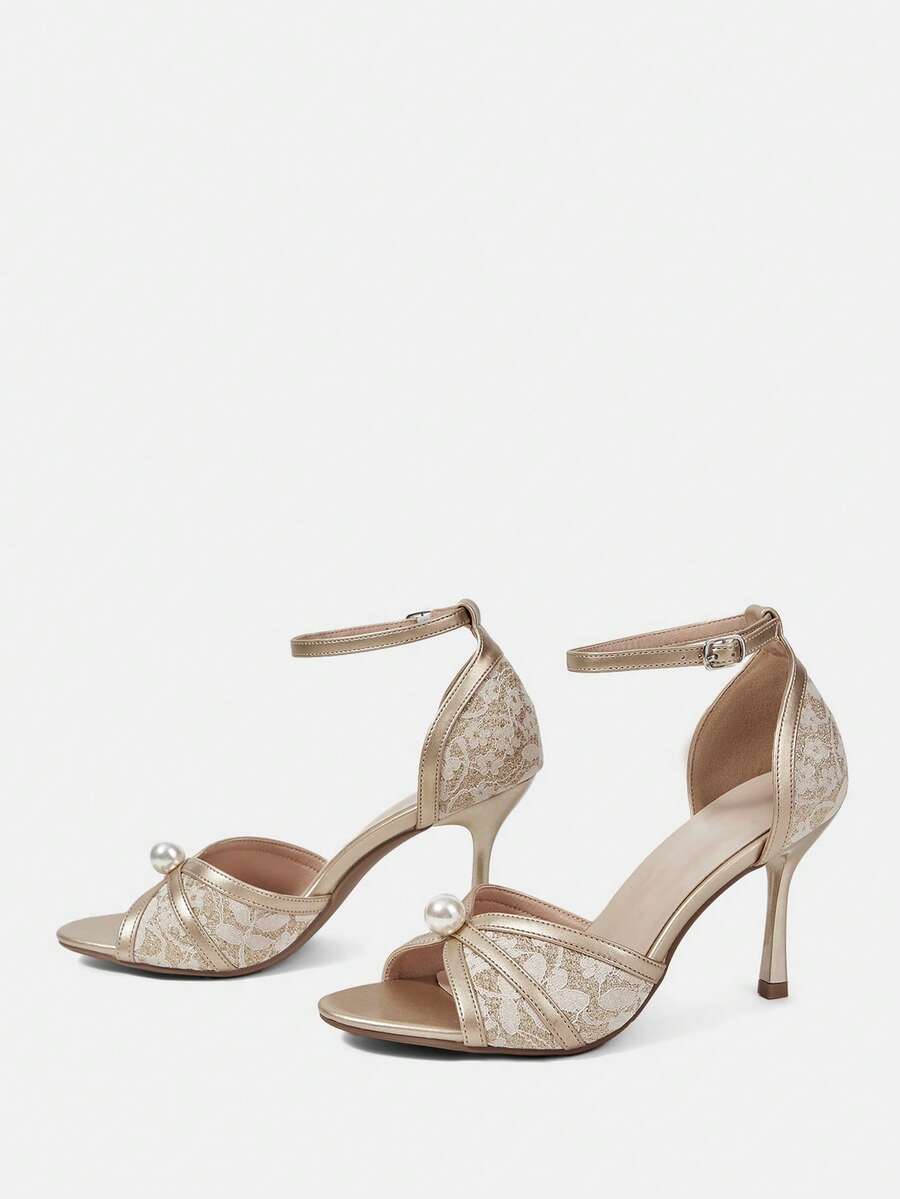 Beige high heel sandals with delicate lace overlay, pearl embellishments, stiletto heel, and adjustable ankle strap for bride and wedding party wear.