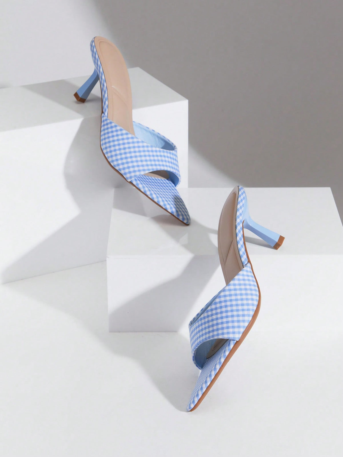 Black pointy toe kitten heel shoes for women featuring a sleek cut out mule design and glossy patent leather finish.