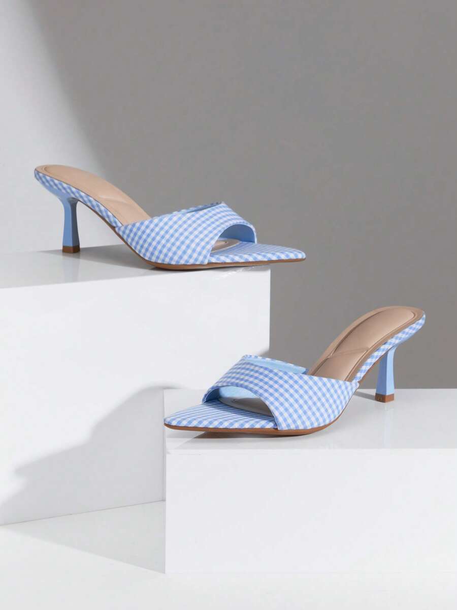 Black pointy toe kitten heel shoes for women featuring a sleek cut out mule design and glossy patent leather finish.