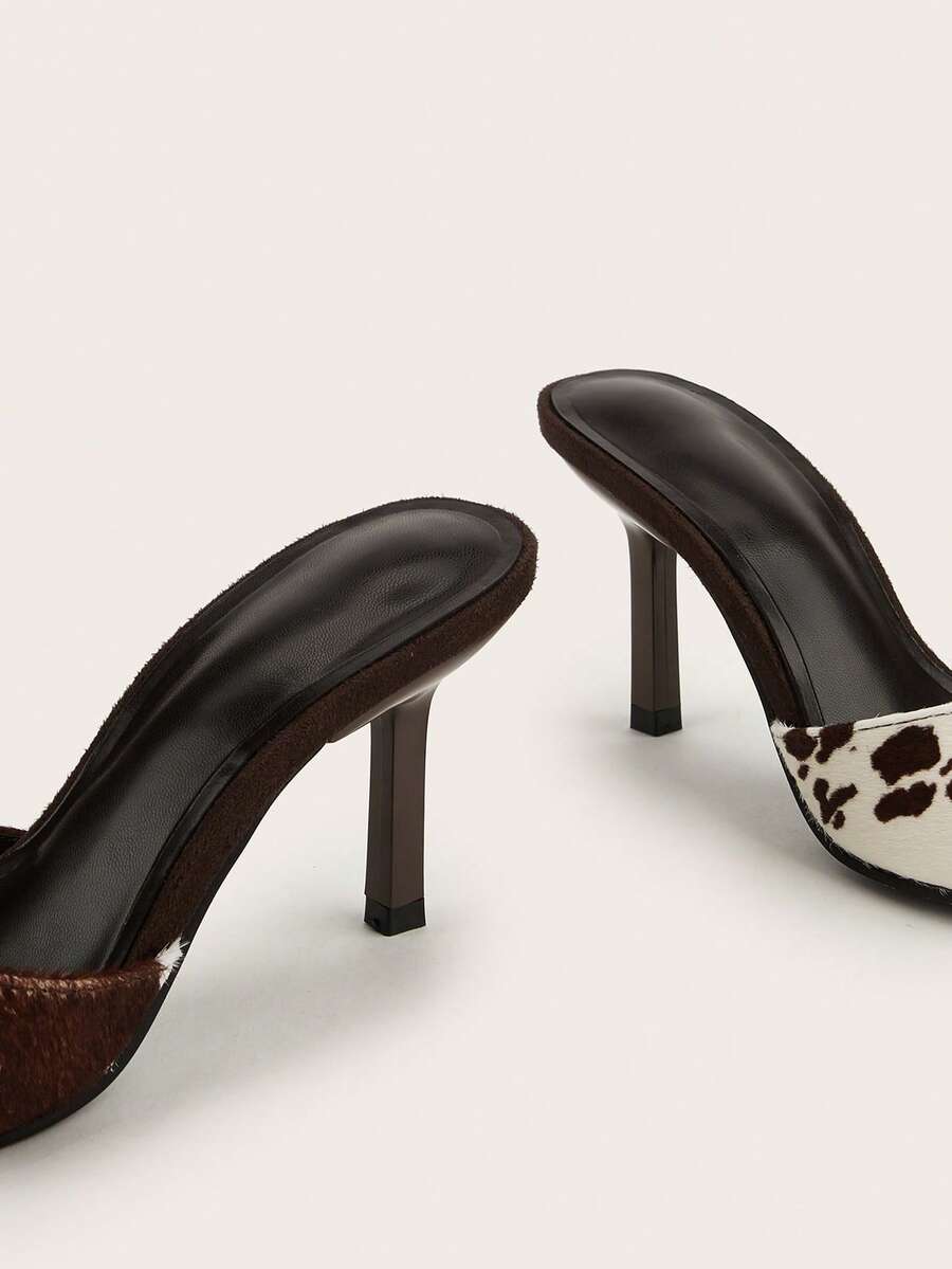 Brown cow print and polka dot stiletto high heel sandals with an open peep toe, satin upper, and buckle accent.