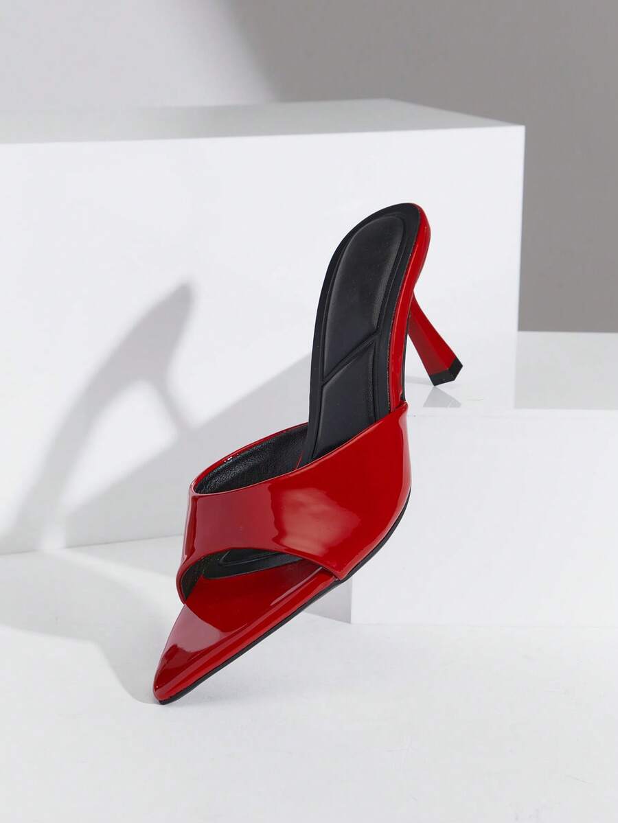 Black pointy toe kitten heel shoes for women featuring a sleek cut out mule design and glossy patent leather finish.