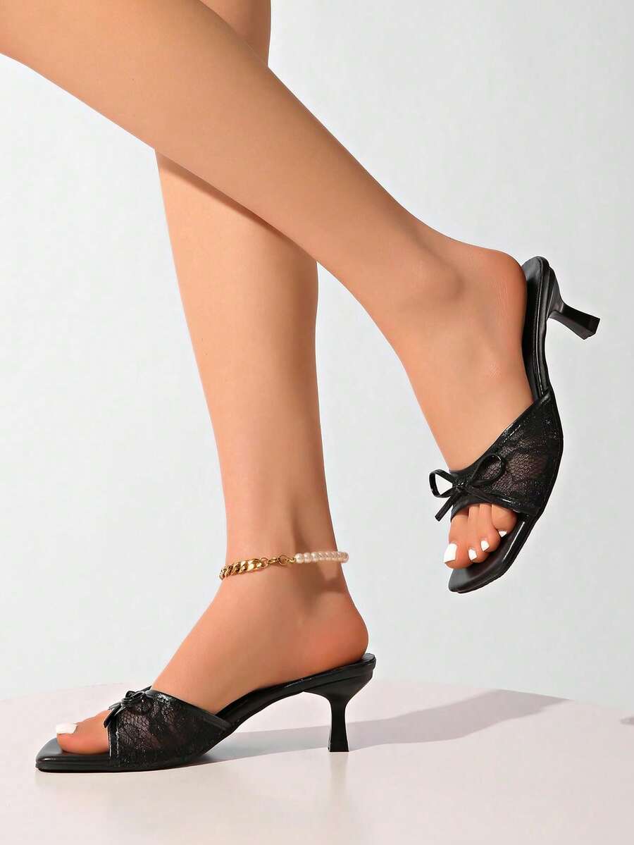 Gold kitten heel mule sandals featuring lace mesh bow detail and an open-toe slip-on design for women.