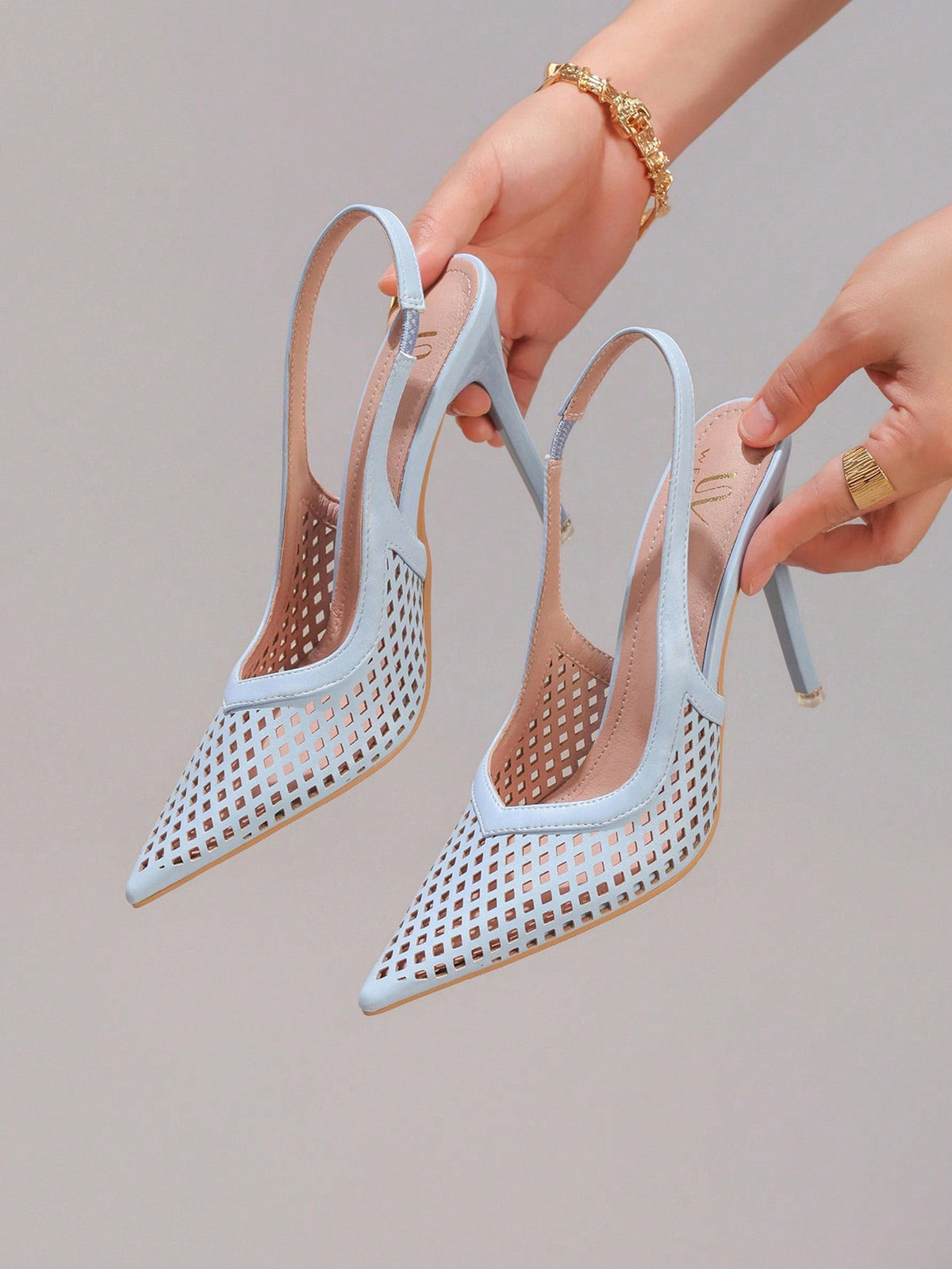 Lace embroidered high heels with thin stiletto heel, pointed toe, rhinestone embellishments, and ankle strap buckle closure.
