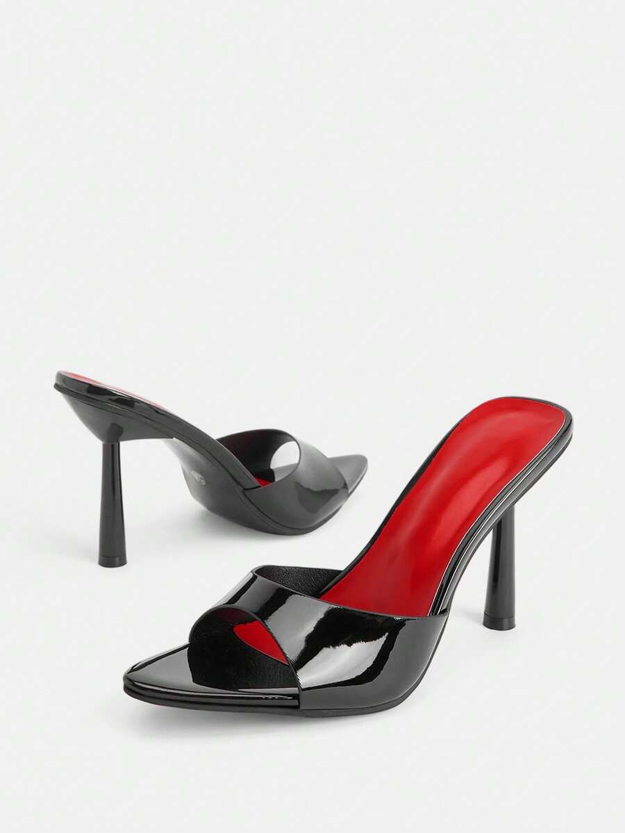 Black pointed toe high heel mules featuring transparent pyramid decor and stiletto heels for women.