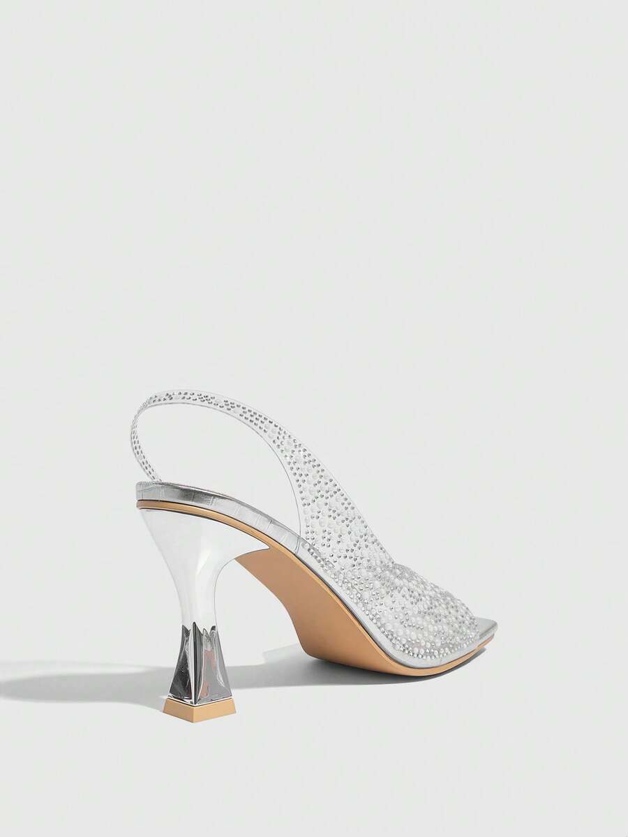 Women's square toe heeled sandals with clear straps, sparkling rhinestone embellishments, and a high pyramid heel.