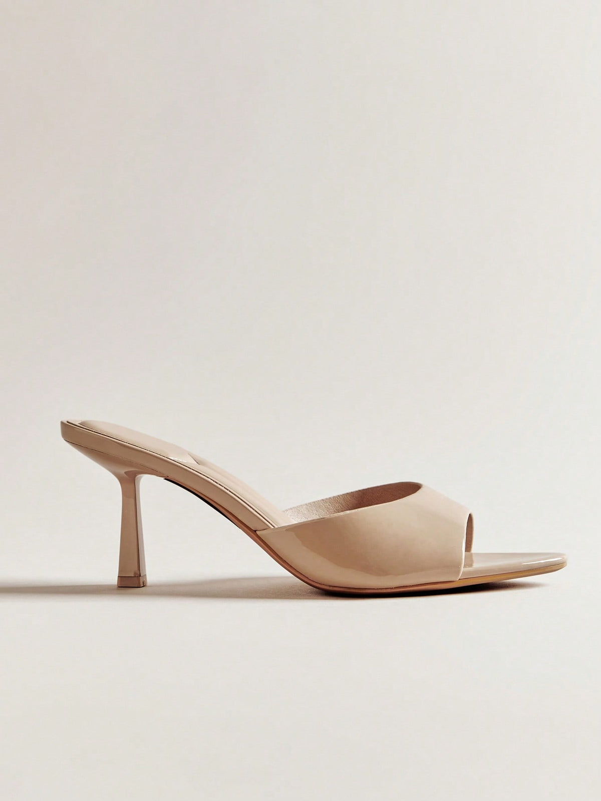 Pair of women's minimalist black pointy toe stiletto heel sandals with slingback straps.