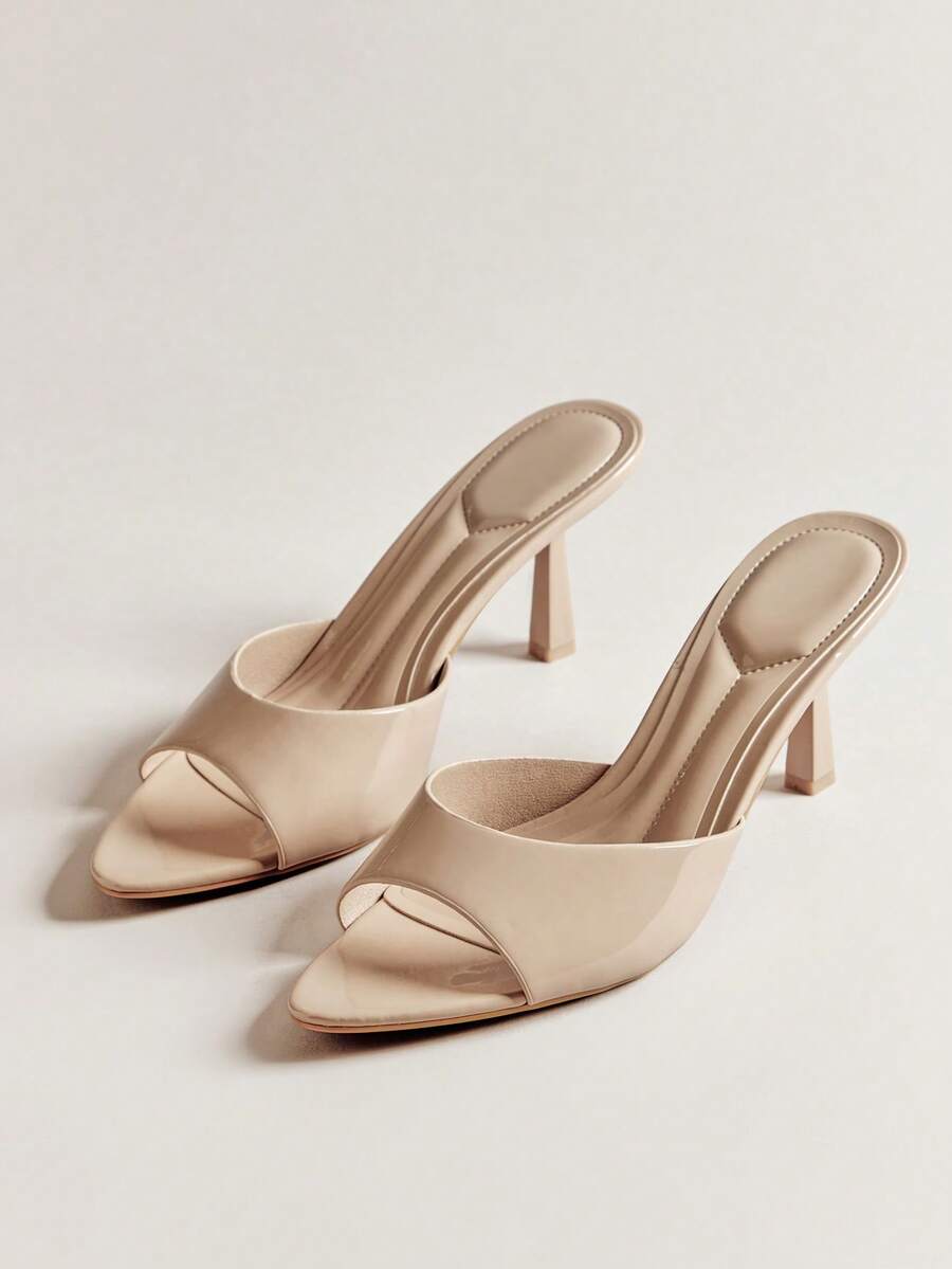 Pair of women's minimalist black pointy toe stiletto heel sandals with slingback straps.