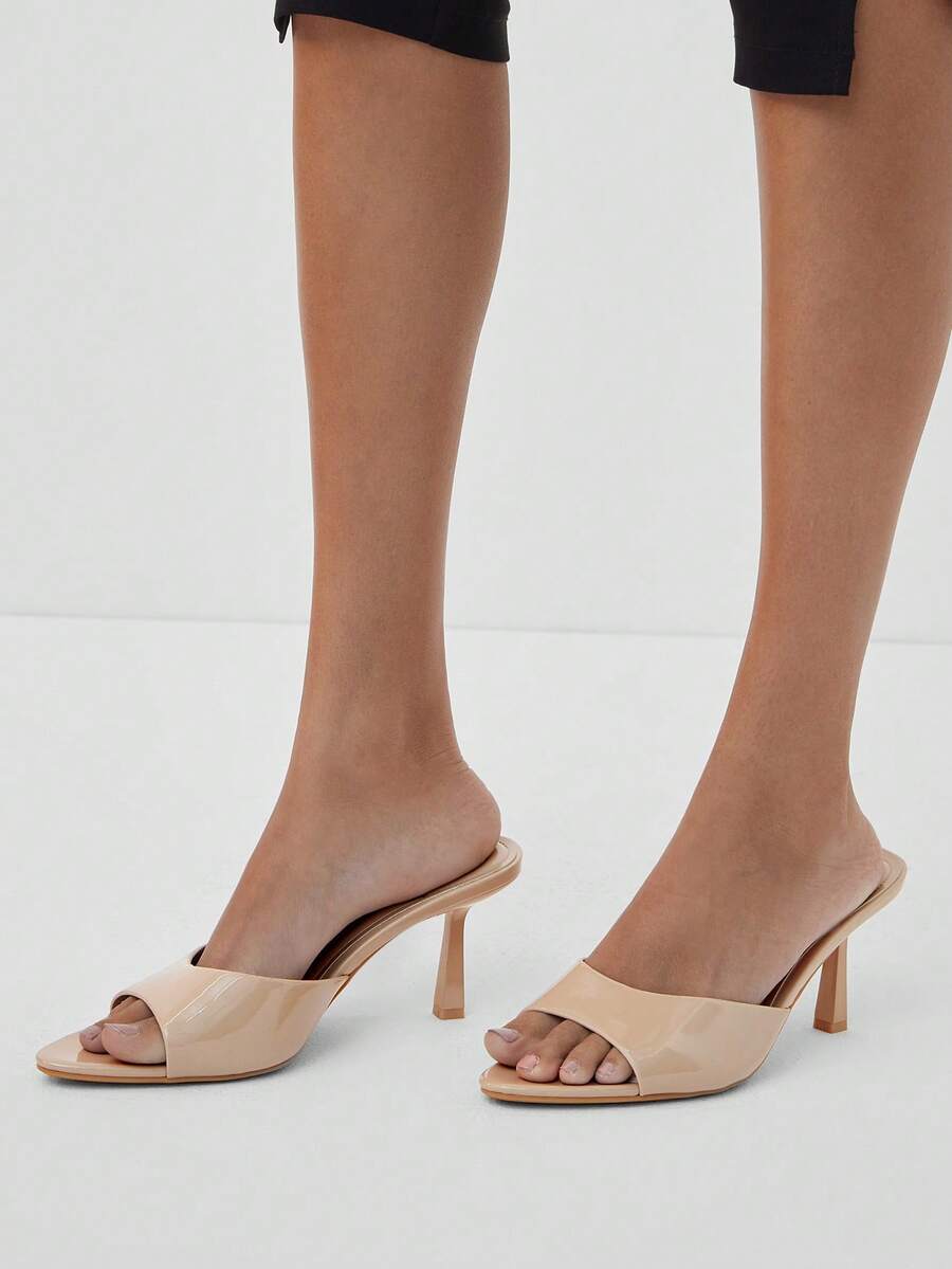 Pair of women's minimalist black pointy toe stiletto heel sandals with slingback straps.