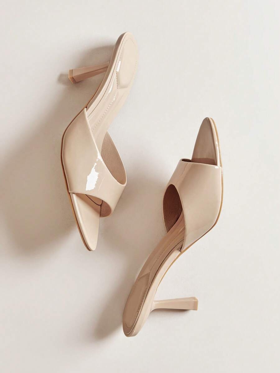 Pair of women's minimalist black pointy toe stiletto heel sandals with slingback straps.