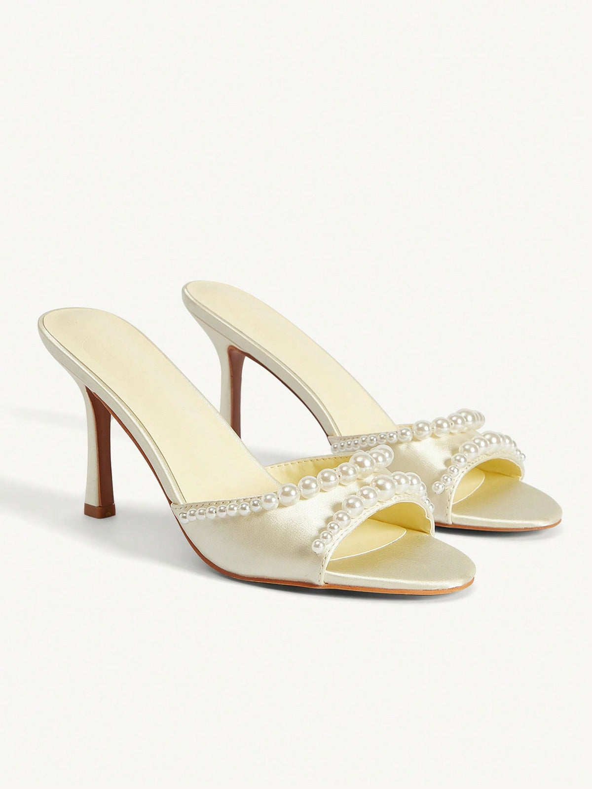 Elegant women's satin high heel sandals with pearl embellishments, stiletto heels, and slingback straps for bridal and wedding wear.
