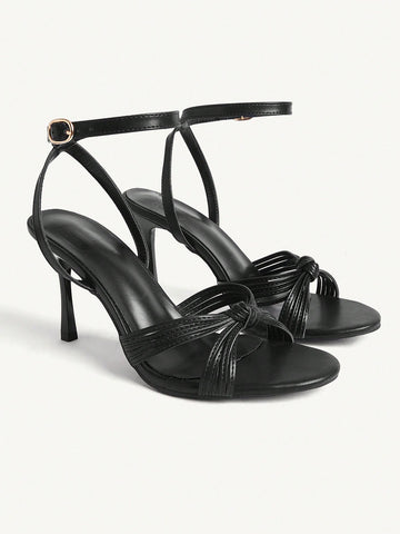 Women's champagne stiletto high heel sandals featuring knotted cross-over straps, open round toe, and adjustable ankle buckle strap.