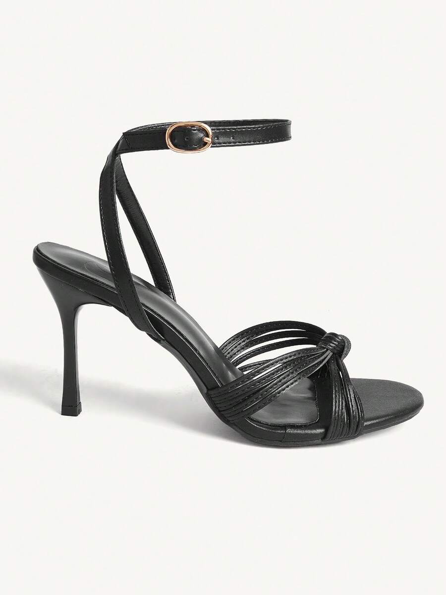 Women's champagne stiletto high heel sandals featuring knotted cross-over straps, open round toe, and adjustable ankle buckle strap.