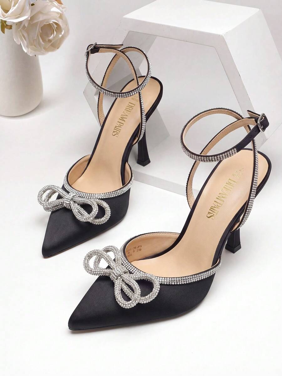 Women's rhinestone ankle strap high heels with pointed closed toe, strappy bow details, and stiletto heel for wedding and prom wear.