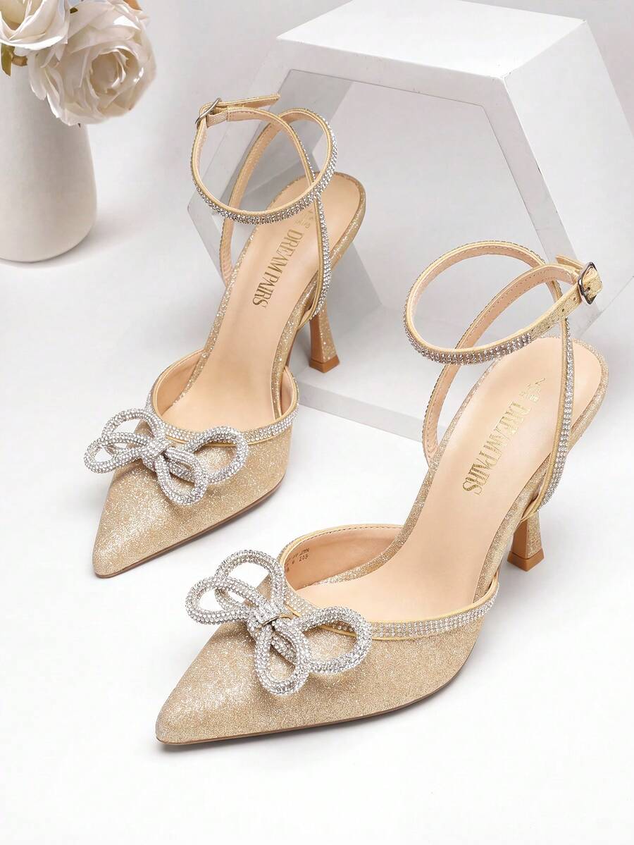 Women's rhinestone ankle strap high heels with pointed closed toe, strappy bow details, and stiletto heel for wedding and prom wear.
