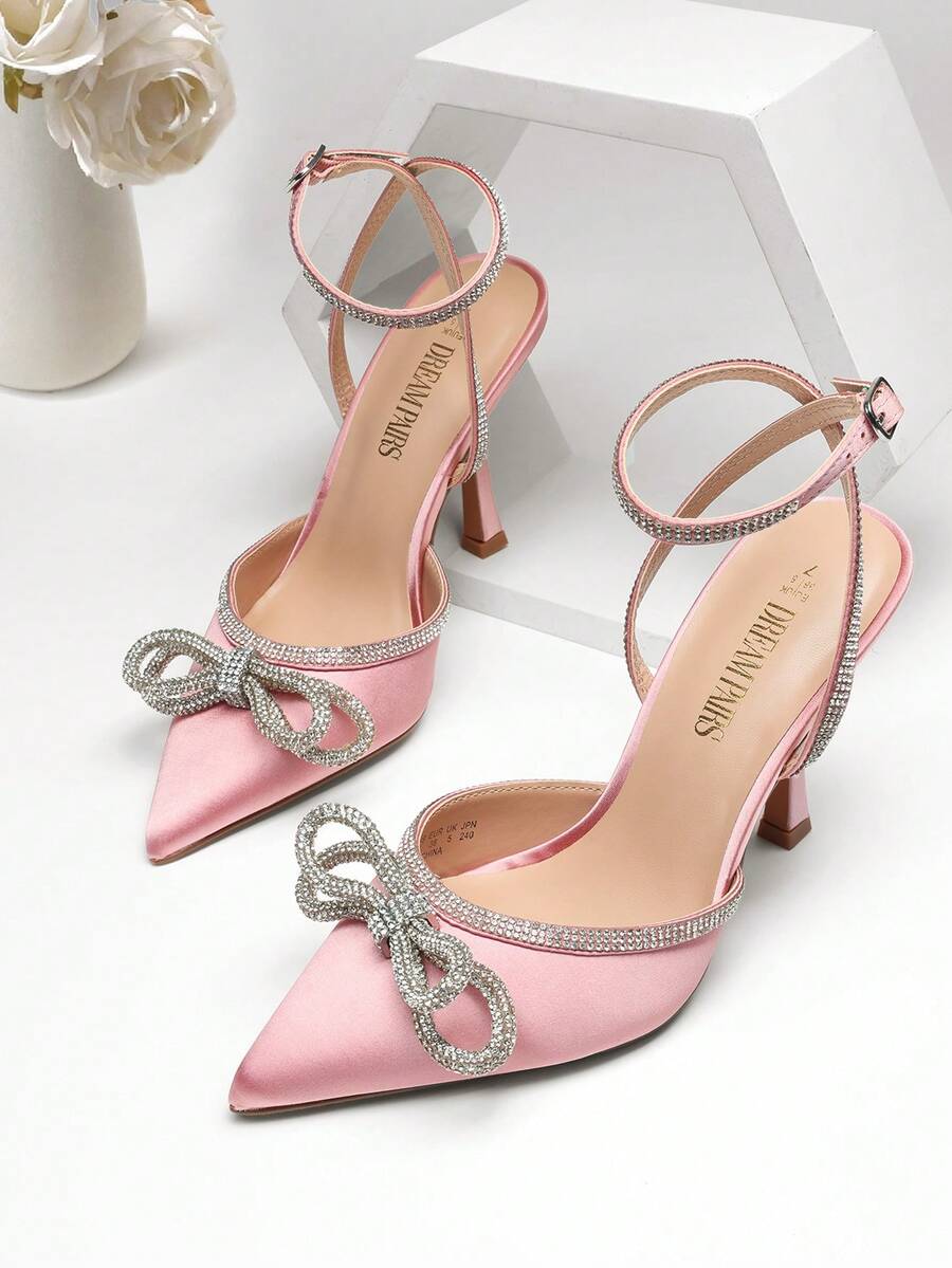 Women's rhinestone ankle strap high heels with pointed closed toe, strappy bow details, and stiletto heel for wedding and prom wear.