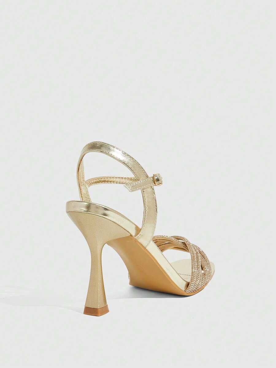 Women's gold open square toe high-heeled sandals featuring a stylish twist strap and stiletto heel.
