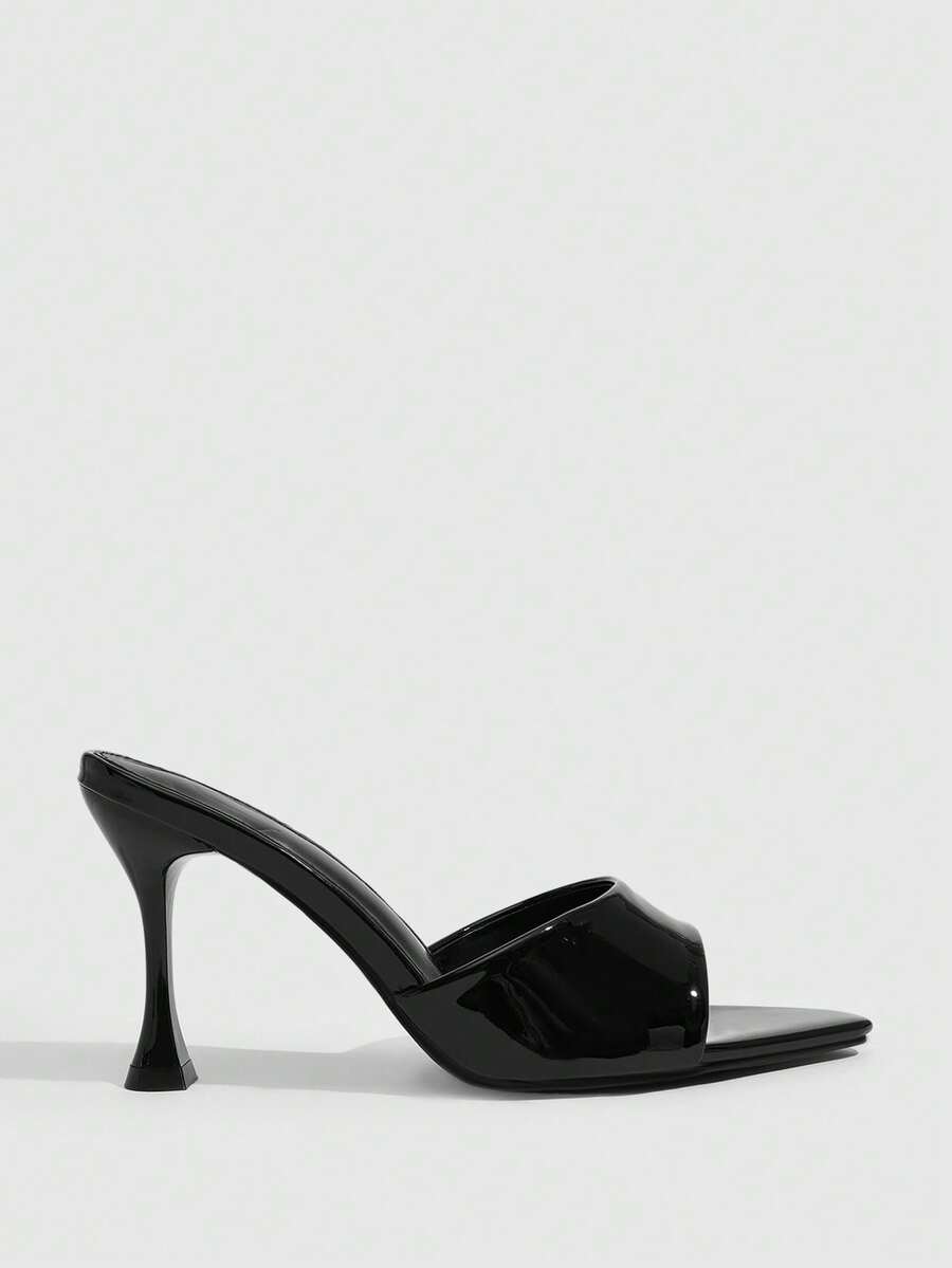Pair of women's pointed toe stiletto mule sandals with shiny patent upper and slip-on design.