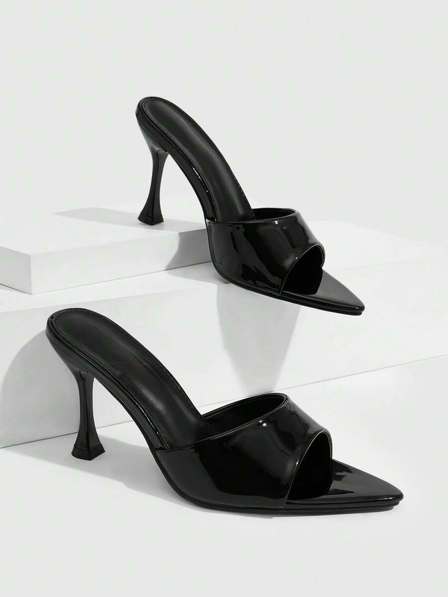 Pair of women's pointed toe stiletto mule sandals with shiny patent upper and slip-on design.
