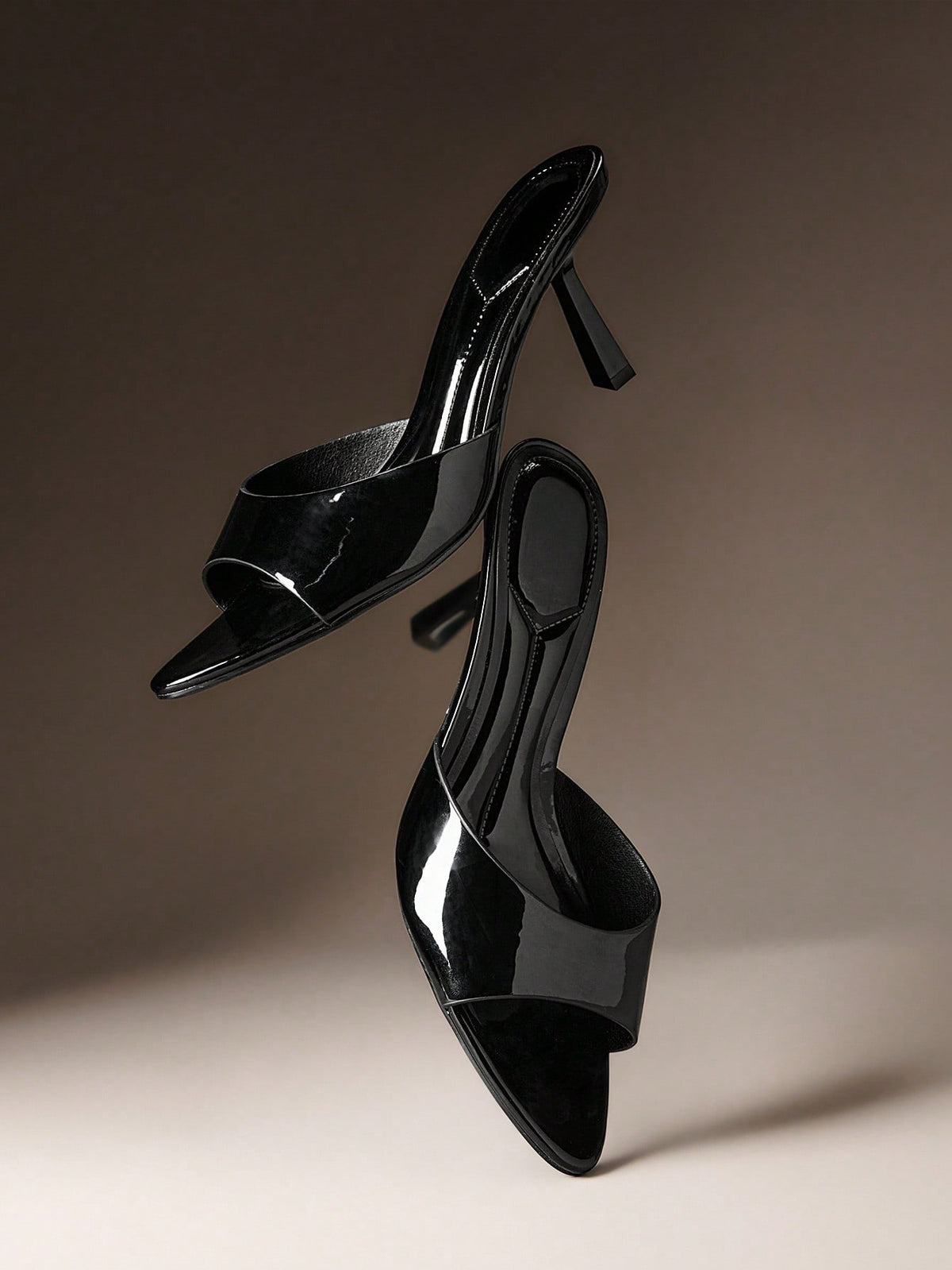 Pair of women's minimalist black pointy toe stiletto heel sandals with slingback straps.