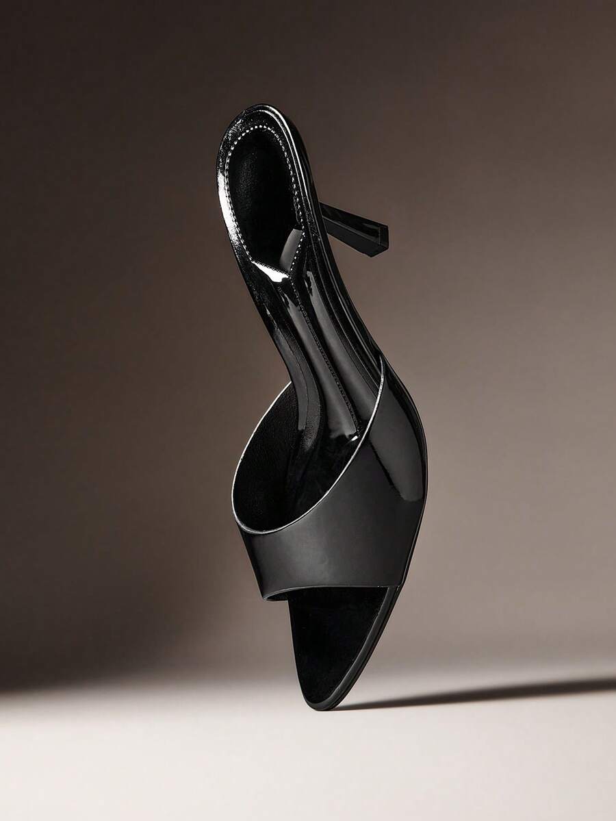 Pair of women's minimalist black pointy toe stiletto heel sandals with slingback straps.