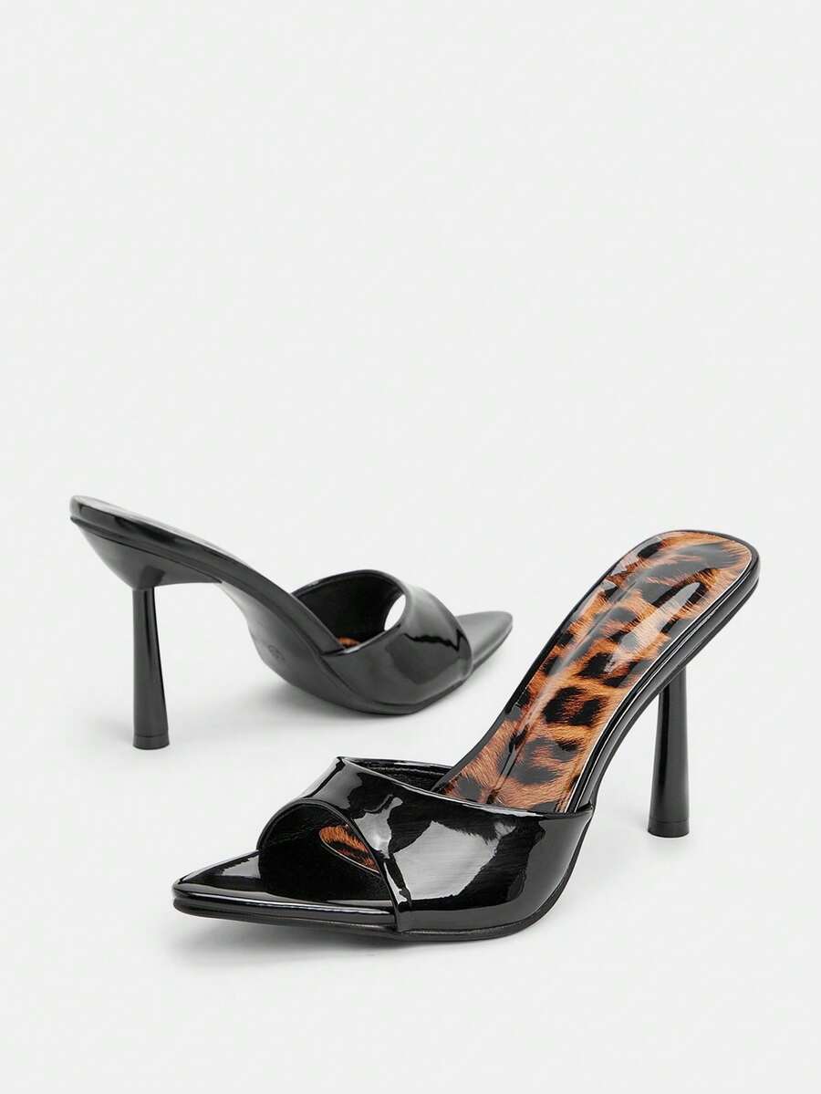 Women's black pointed toe high heel mule sandals featuring pyramid decor accents on a sleek slip-on silhouette.