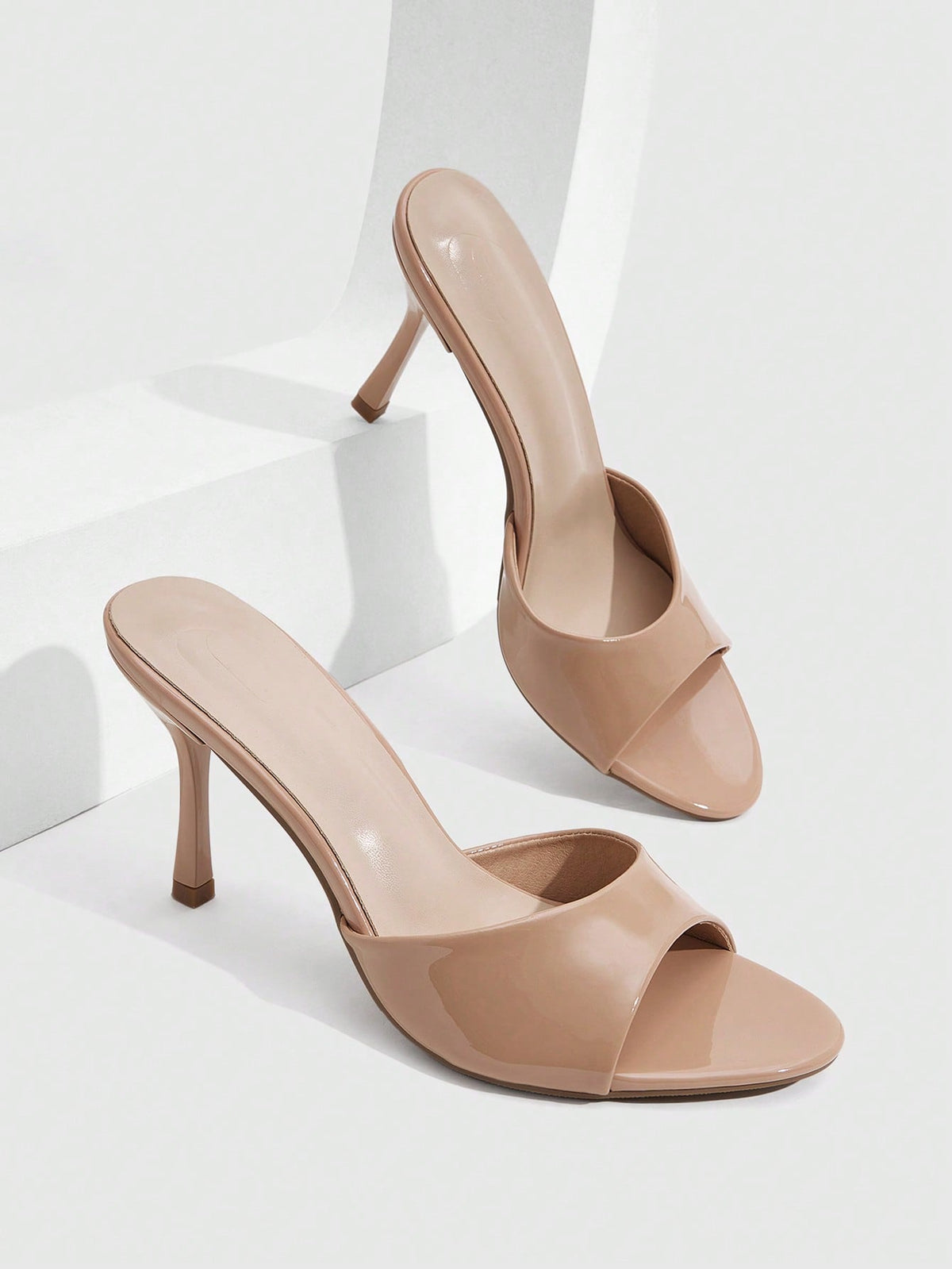Women's peep toe high-heeled stiletto sandals with slingback strap in light metallic finish.