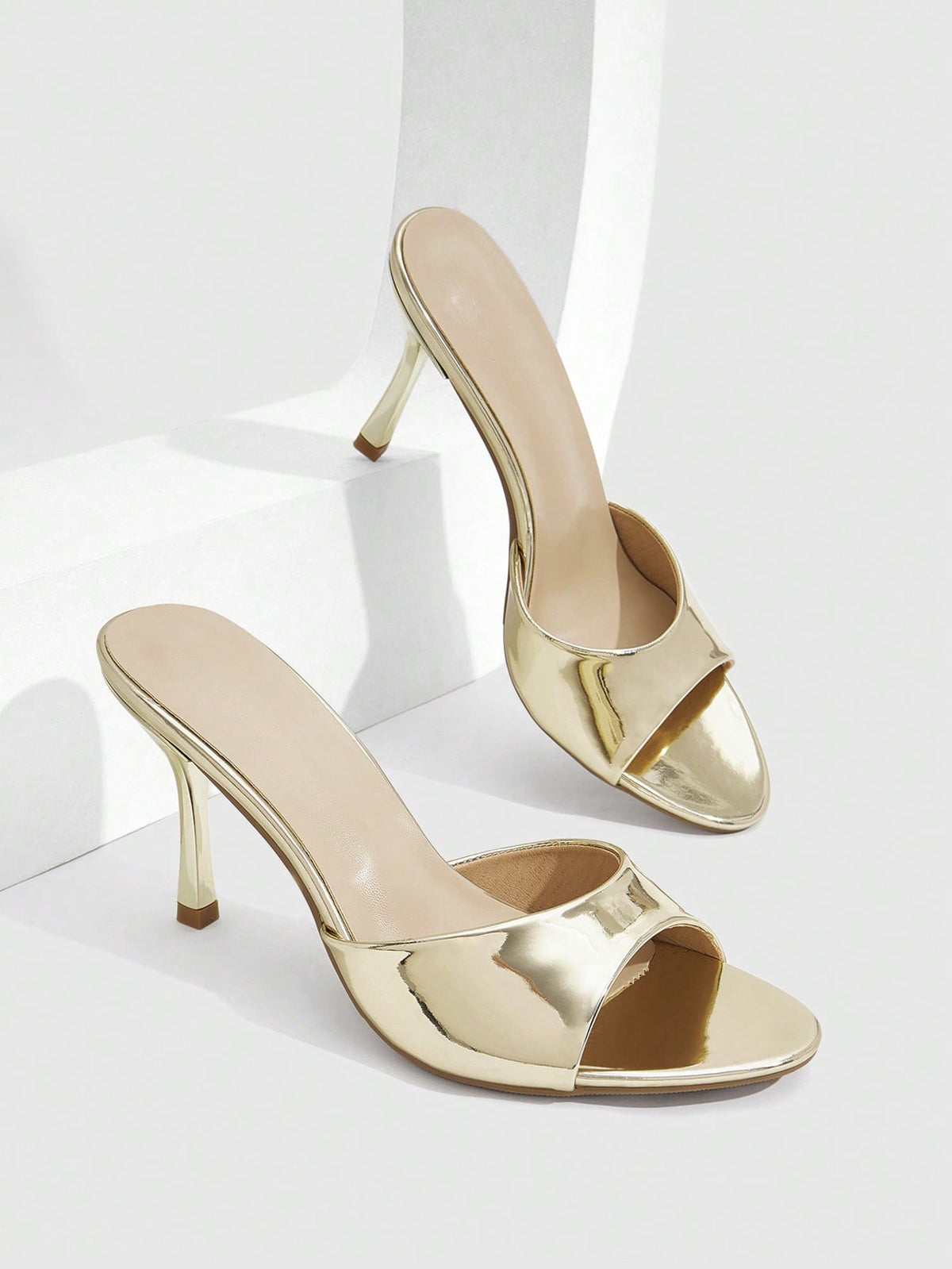 Women's peep toe high-heeled stiletto sandals with slingback strap in light metallic finish.