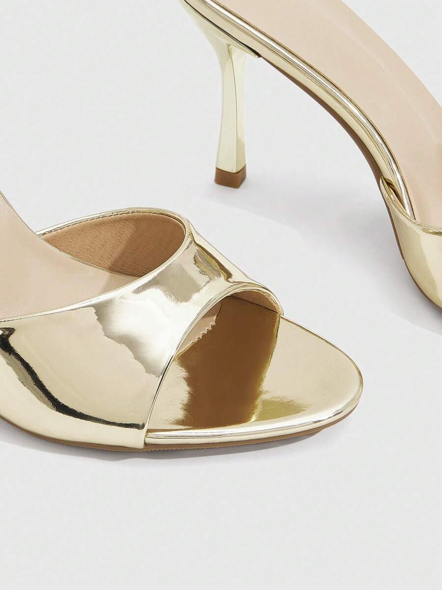 Women's peep toe high-heeled stiletto sandals with slingback strap in light metallic finish.