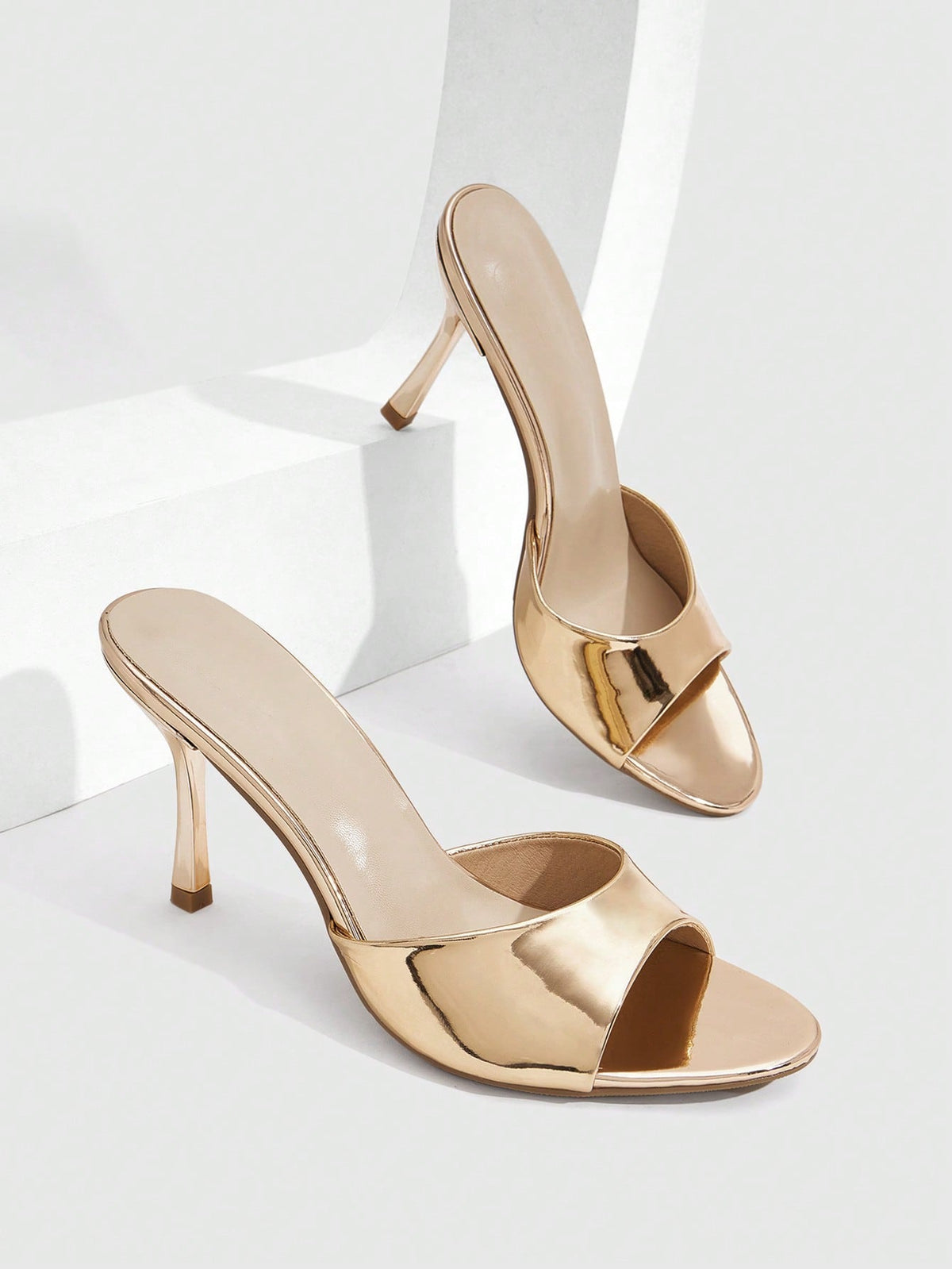Women's peep toe high-heeled stiletto sandals with slingback strap in light metallic finish.