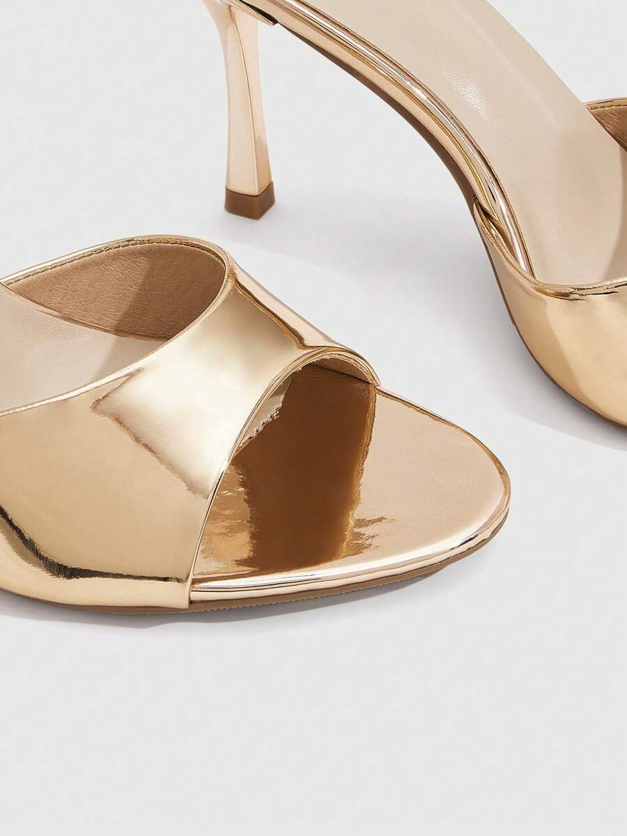 Women's peep toe high-heeled stiletto sandals with slingback strap in light metallic finish.
