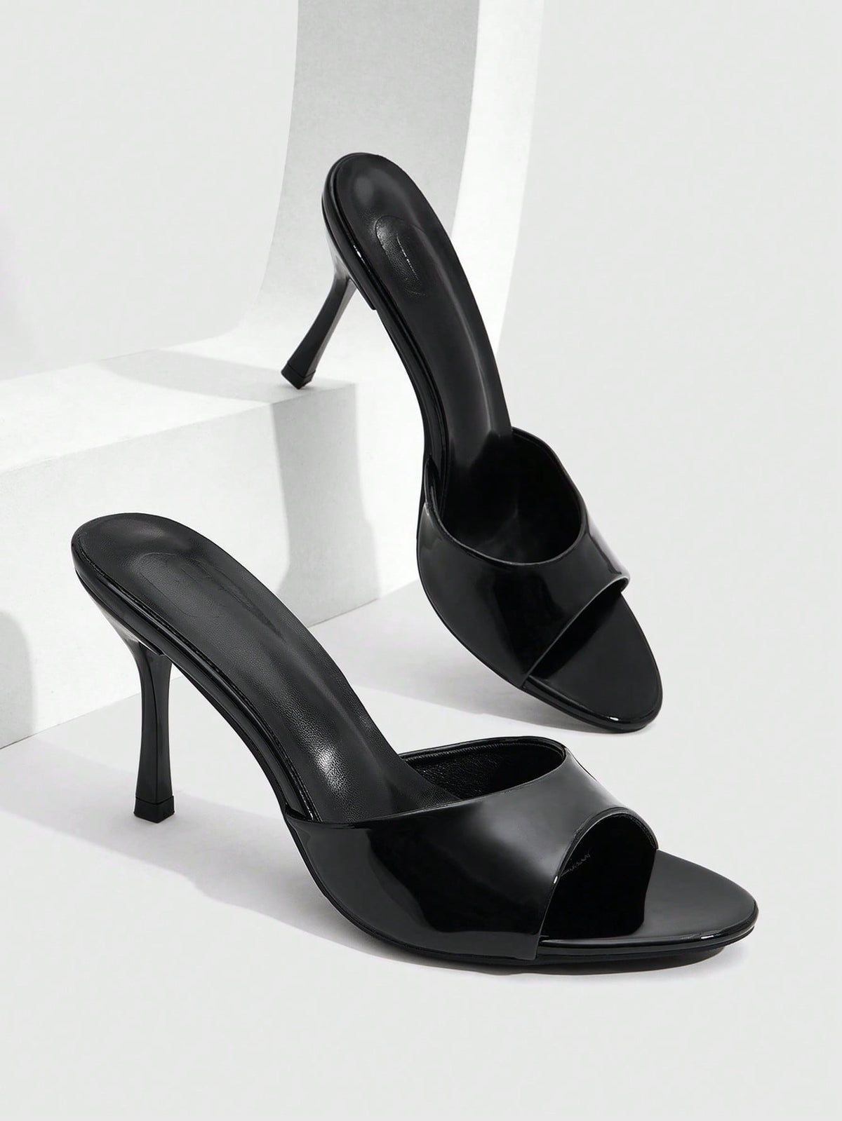 Women's peep toe high-heeled stiletto sandals with slingback strap in light metallic finish.